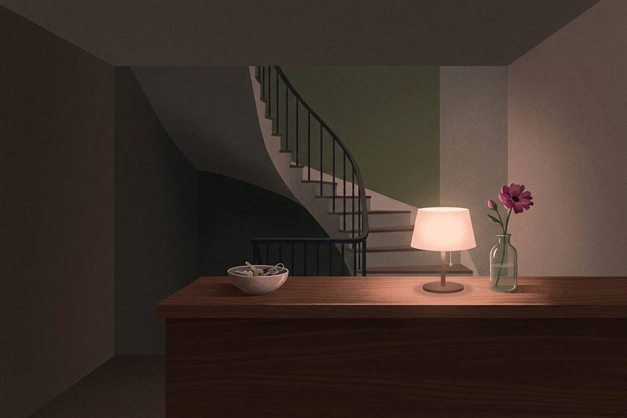 A quiet basement reception counter with a lamp and a bowl of keys